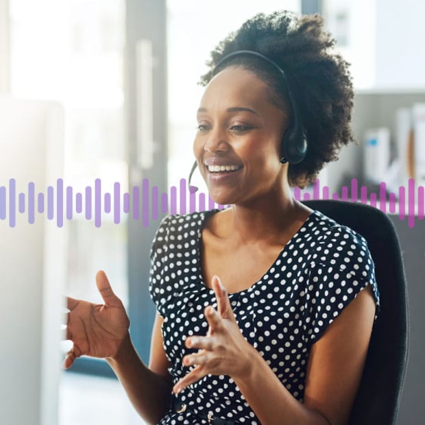 Photo of a smiling agent sitting at her computer talking to a customer through her headset. A series of small vertical lines representing sound run across the frame.